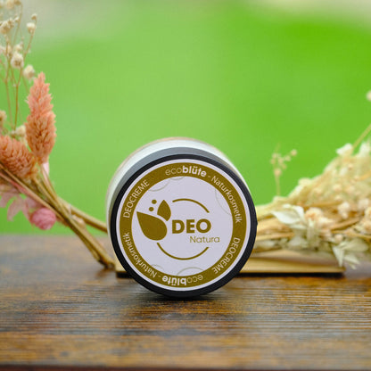Deo-Creme Natura mit Gesteck im Hintergrund