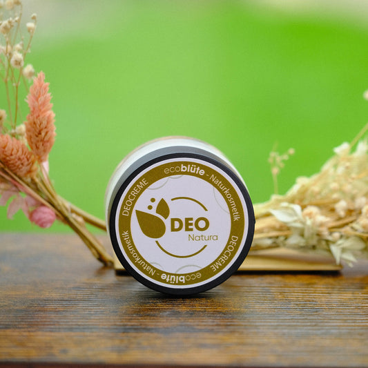Deo-Creme Natura mit Gesteck im Hintergrund