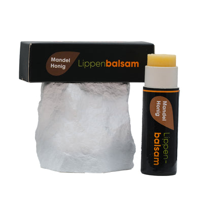 Lippenpflege Stift Mandel-Honig mit Verpackung auf Stein