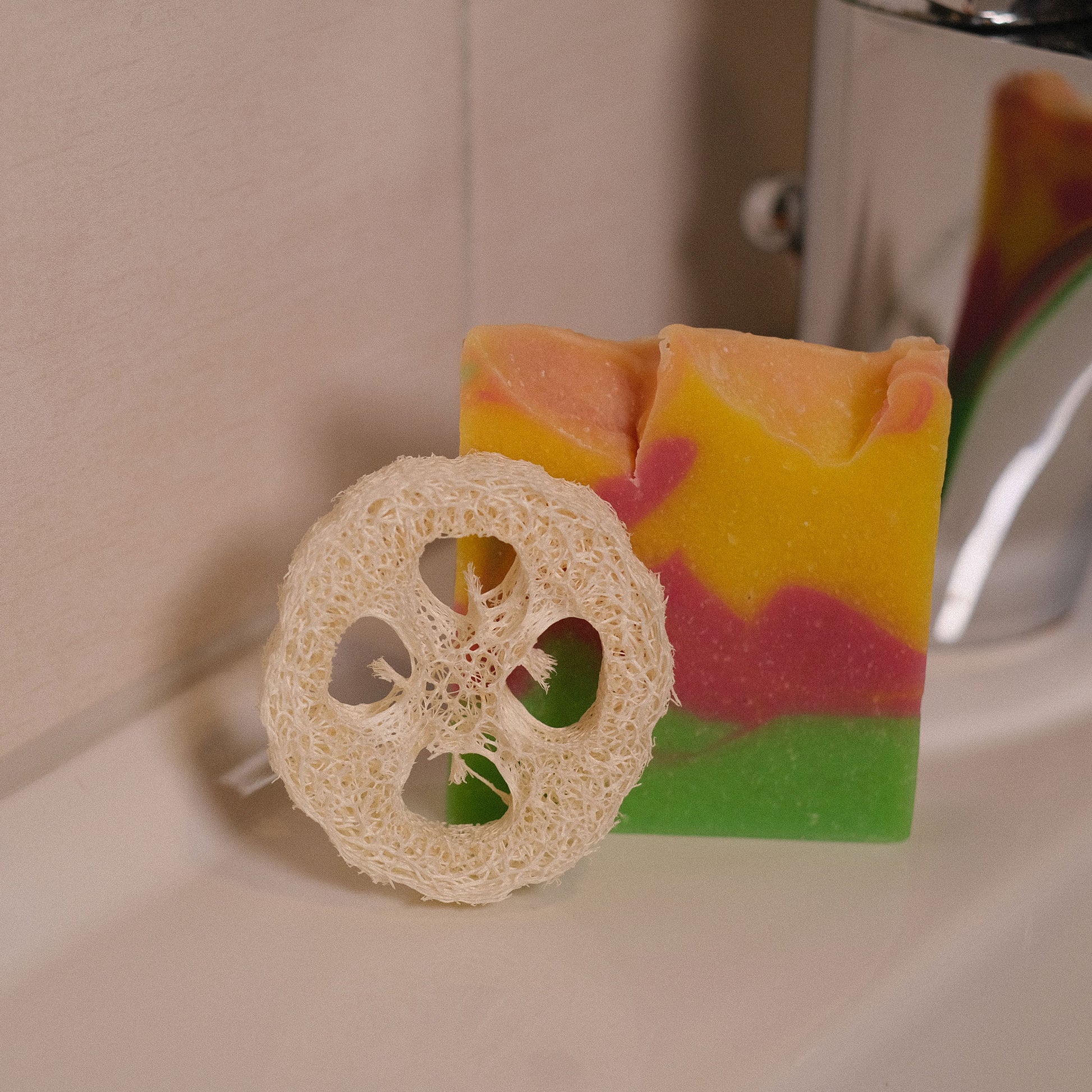 Naturseife Blütenzauber mit Luffa-Scheibe stehend am Waschbecken
