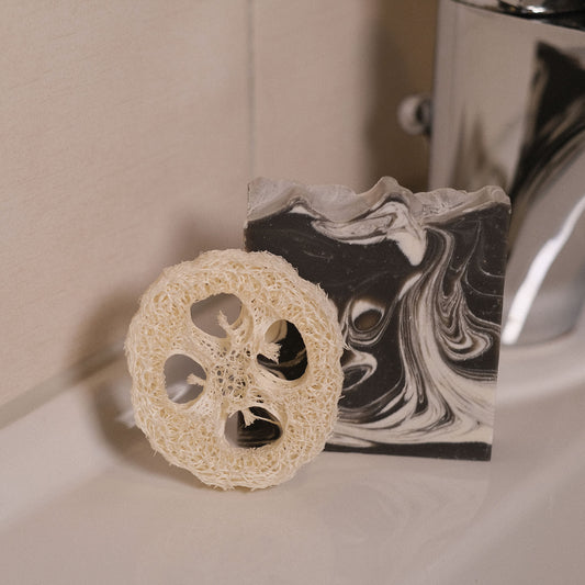 Naturseife Fesh mit Luffa-Scheibe stehend am Waschbecken