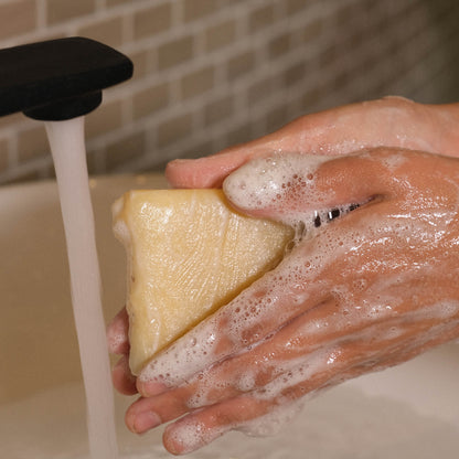 Naturseife Natura beim Händewaschen unter einem Wasserstrahl mit Schaum an den Händen