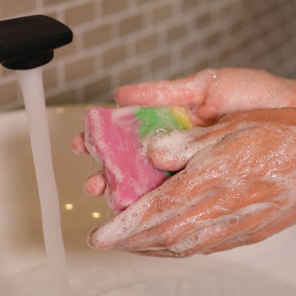 Naturseife Blütenzauber beim Händewaschen unter einem Wasserstrahl mit Schaum an den Händen
