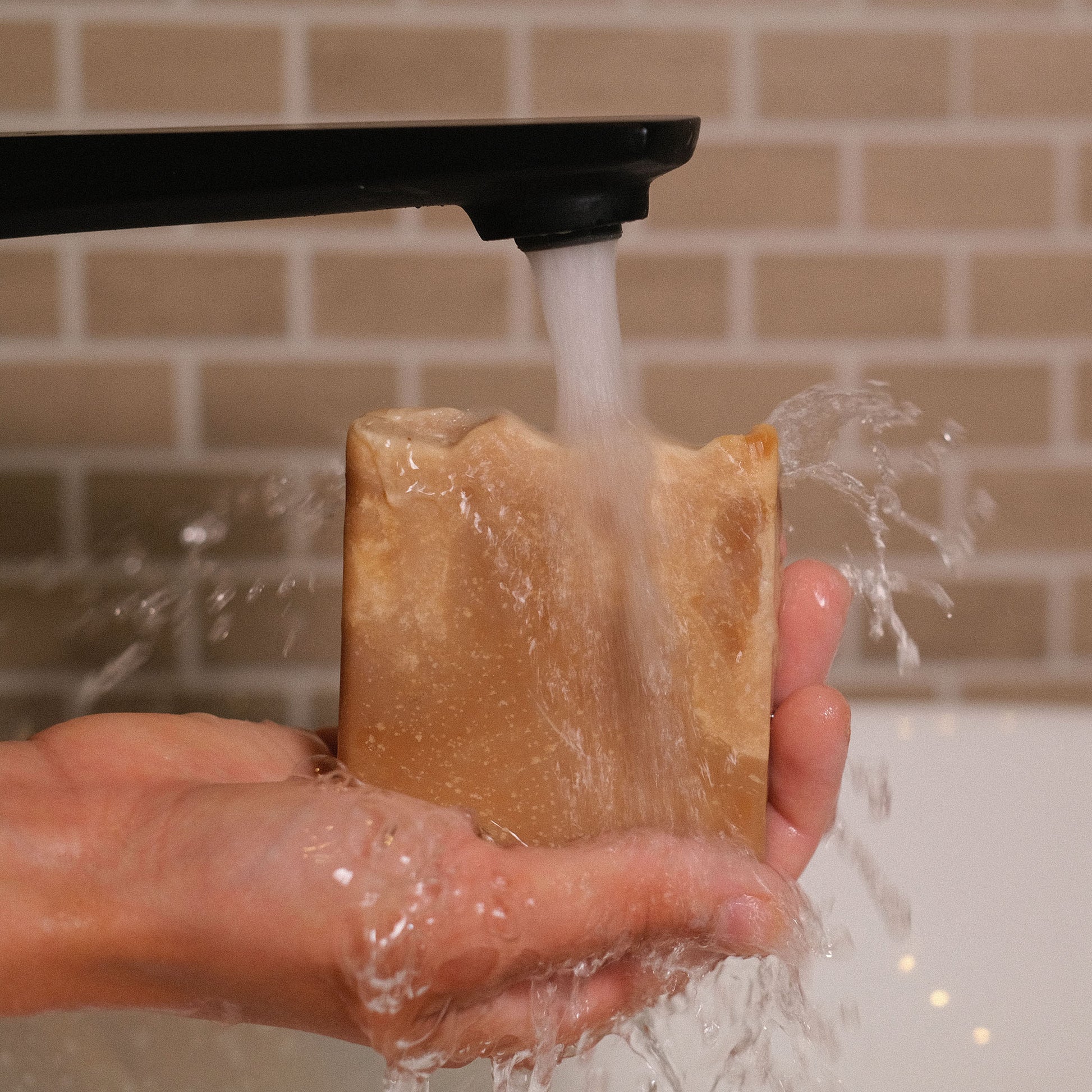 Naturseife Kleopatra beim Händewaschen unter einem Wasserstrahl