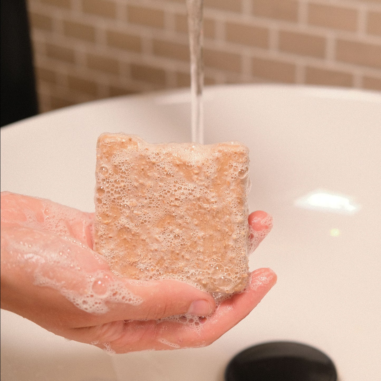 Naturseife KOKO beim Händewaschen unter einem Wasserstrahl