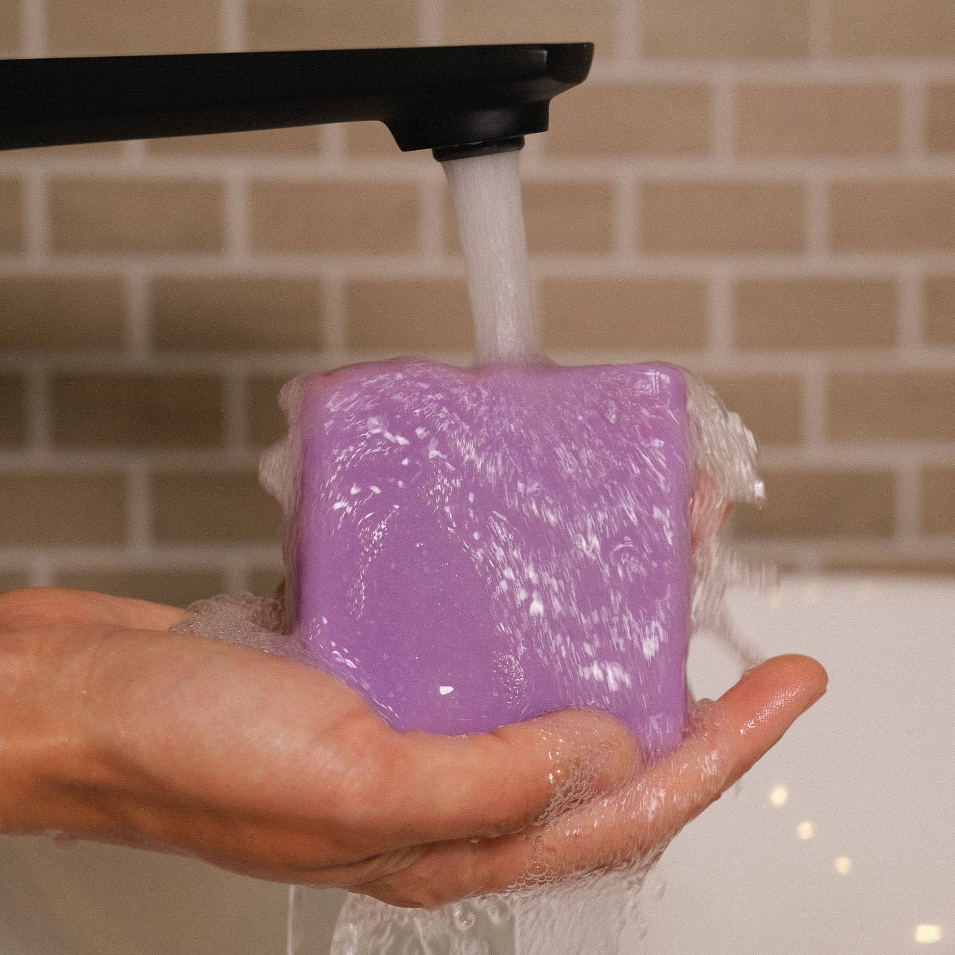 Naturseife Lavendella beim Händewaschen unter einem Wasserstrahl