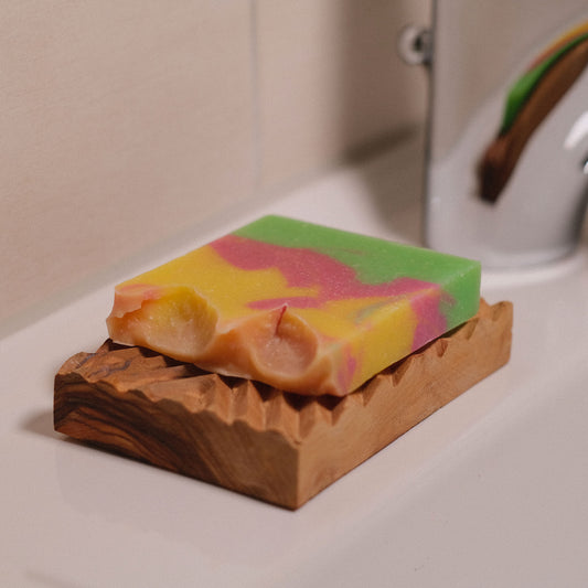 handgefertigte Olivenholz Seifenablage mit unserer Naturseife Blütenzauber am Waschbecken