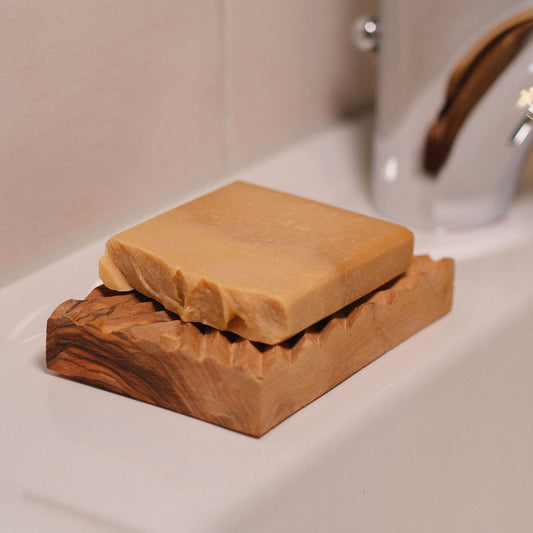 Seifenschale mit Seife am Waschbecken
handgefertigte Olivenholz Seifenablage mit unserer Naturseife Kleopatra am Waschbecken
